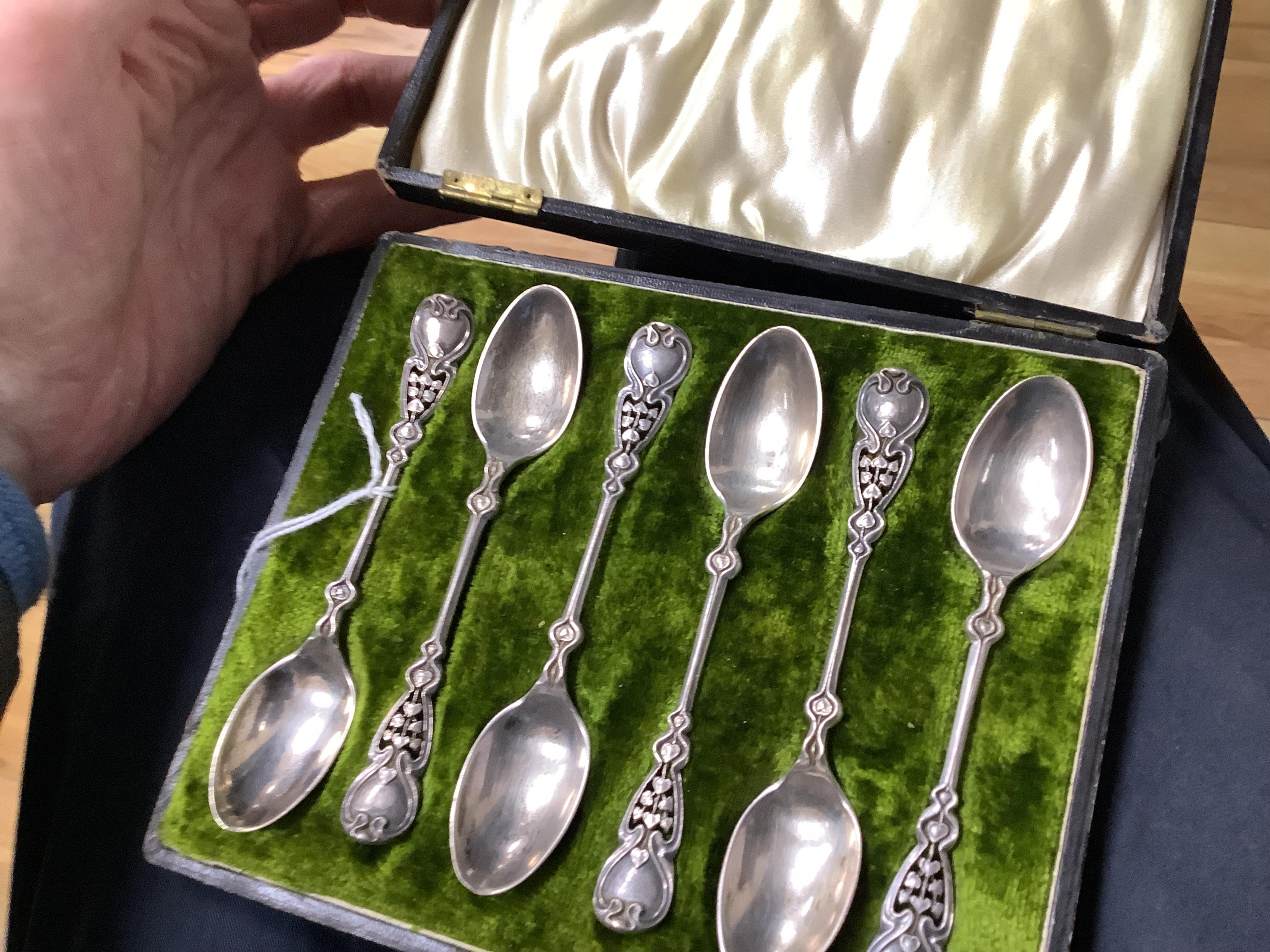 A cased set of six Edwardian Art Nouveau silver coffee spoons, Joseph Rodgers & Sons, Sheffield, 1908, 10.9cm, with pierced stylised terminals.